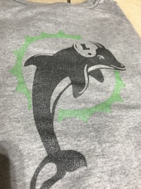 a grey t - shirt with a dolphin on it