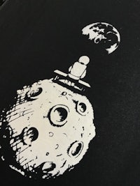 a black and white drawing of a moon on a black background